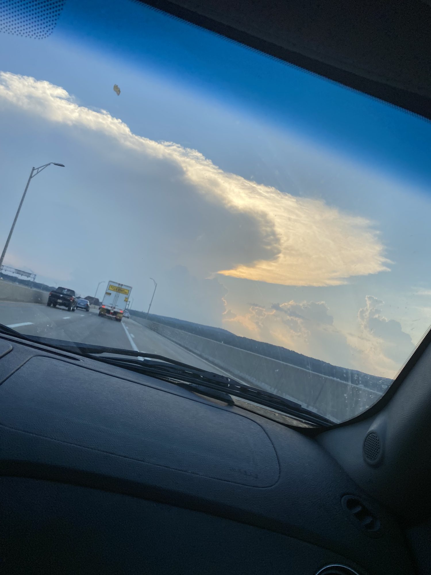 Golden-hour clouds over the highway, shot from the car