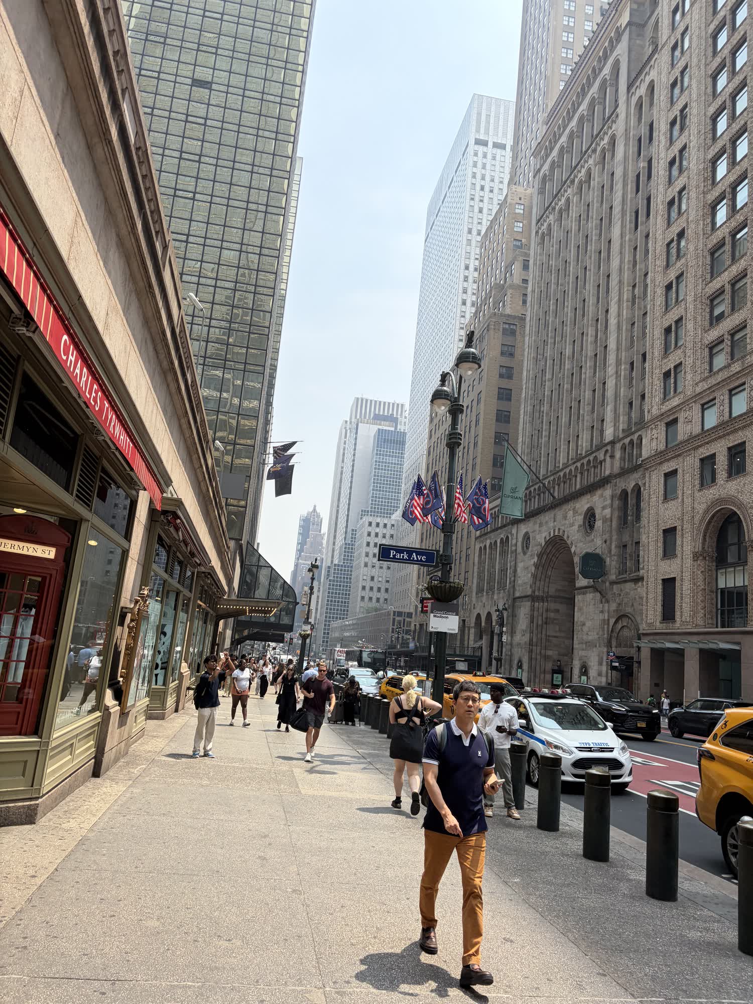 Park Avenue in Midtown on a hazy summer day, flags on the lamppost, cabs at the curb